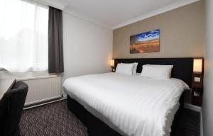 a hotel room with a large bed and a large window at Wynnstay Arms, Wrexham by Marston's Inns in Wrexham