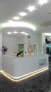 a lobby with a white counter in a room at Hotel Holland in Rimini