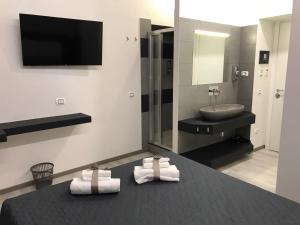 a bathroom with a sink and a mirror and towels at Sangiò Guest House in Rome