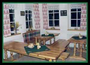 um quarto com mesas de madeira num quarto com janelas em Penzion Krasula em Ždiar