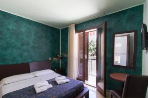 a bedroom with green walls and a bed with towels at Villa Margherita in Pozzallo +101 photos