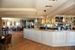 a bar in a restaurant with tables and chairs at Blue Jay, Derby by Marston's Inns in Derby