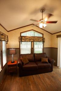 a brown couch in a living room with a ceiling fan at Yukon Trails Camping Resort in Lyndon Station
