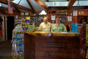 two men standing at a counter in a store at Yukon Trails Camping Resort in Lyndon Station