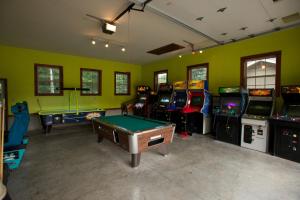 a room with many arcade games and a pool table at Yukon Trails Camping Resort in Lyndon Station