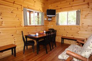 comedor con mesa en una cabaña de madera en Neshonoc Lakeside Camping Resort, en West Salem
