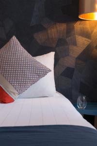 a bed with a white comforter and pillows at Hotel France Albion in Paris