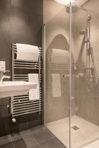 y baño con ducha y lavamanos. en Hotel France Albion en París
