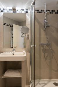 a bathroom with a shower, sink, and toilet at Hotel France Albion in Paris