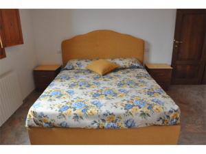 a bedroom with a bed with blue and yellow flowers at Appartamenti fronte mare in Castiglioncello