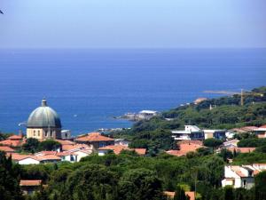 a town on a hill with the ocean in the background at Appartamenti fronte mare in Castiglioncello