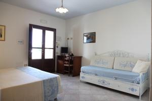 a bedroom with two beds and a table and a window at Hotel Resort Nuraghe Arvu in Cala Gonone