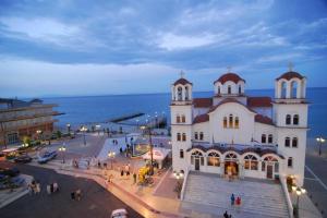 a large white building with people walking in front of it at Philippos Hotel in Paralia Katerinis