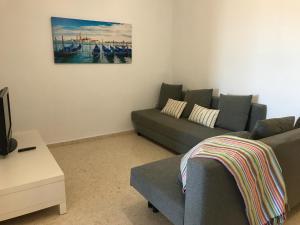 ein Wohnzimmer mit Sofa und Fernseher in der Unterkunft Apartamento PortSaplaya in Port Saplaya