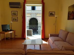 a living room with a couch and a window at Piazza Politeama in Palermo
