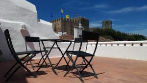 dos sillas y una mesa en un techo con un castillo en Casa da Talhada - Stone House, en Óbidos