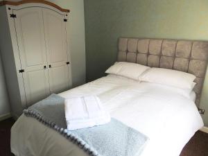 ein Bett mit zwei weißen Handtüchern darüber in der Unterkunft Exquisite Apartment Hessle in Hessle
