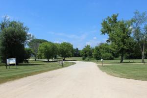 a dirt road in a park with trees at Pine Country Camping Resort in Belvidere