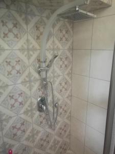 y baño con ducha y cabezal de ducha. en Casa Rosa, en Eilat