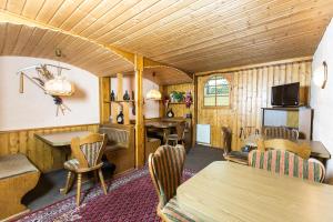 a living room with wooden walls and tables and chairs at Hotel & Reitsportzentrum Kreuth in Heideck