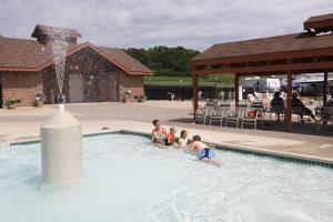 a group of children in a swimming pool with a fountain at Neshonoc Lakeside Camping Resort in West Salem