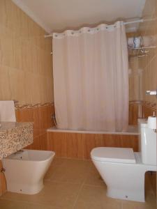 a bathroom with a toilet and a shower curtain at Apartamentos Turisticos Las Yucas in Torre del Mar