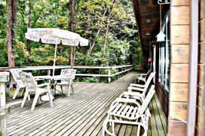 a wooden deck with a table and chairs and an umbrella at Bear Cave Camping Resort in Buchanan