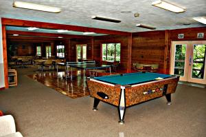 a room with a pool table and ping pong tables at Bear Cave Camping Resort in Buchanan
