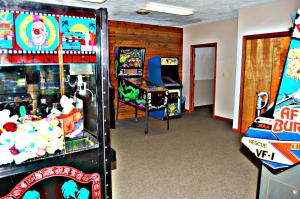 a room with two pinball machines and a video game at Bear Cave Camping Resort in Buchanan