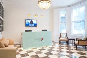 a waiting room with a table and chairs at The Villa Kensington in London