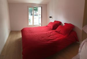 a red bed in a room with a window at L'Île de Lumière in Rivedoux-Plage +19 photos