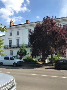 a white building with cars parked in front of it at The Courtyard Apartment in Leamington Spa