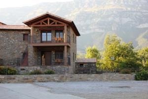a house with a balcony with mountains in the background at Casa sierra ferrera in Samper