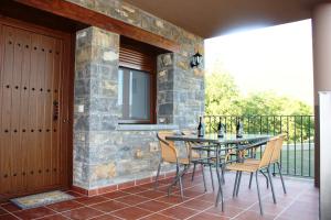 a patio with a table and chairs on a balcony at Casa sierra ferrera in Samper