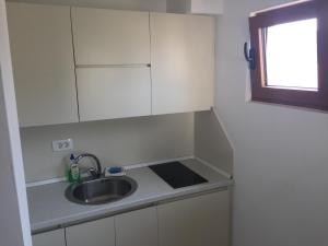 a small kitchen with a sink and a window at Apartments Matkovic Lux in Sutomore