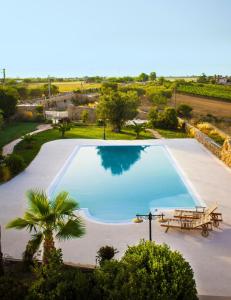 a large swimming pool with a picnic table and a bench at Masseria D'Aprile in Castellaneta
