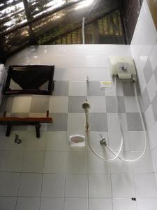 a bathroom with a toilet on a tiled floor at Fisherman's Hut , ขนำชาวเลโฮมสเตย์ in Pak Meng