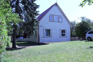 a blue house with a tree in a yard at La Palanga in Palanga