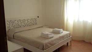 ein Schlafzimmer mit einem Bett mit Handtüchern darauf in der Unterkunft Don Diego Apartment Orosei in Orosei