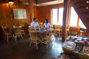 a man and woman sitting at a table in a restaurant at Kandahar Lodge at Whitefish Mountain Resort in Whitefish