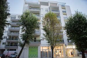 a white building with trees in front of it at Apartman LUNA in Trebinje