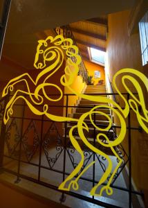 a yellow metal horse statue on a railing at Albergo Cavallino in Tortona