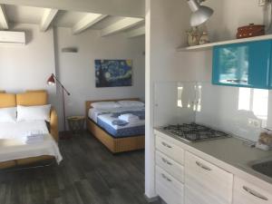 トッレ・ヴァードにあるVilla Cà del Mar Loftのベッド1台付きの部屋、キッチン(コンロ付)