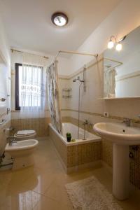 a bathroom with a toilet and a tub and a sink at Residence Le Saline in Marsala