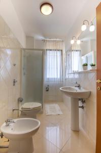 a bathroom with a toilet and a sink and a shower at Residence Le Saline in Marsala