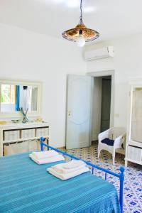 a blue bed in a room with a blue table at Le Mànnare Case Vacanze di Metopa srl in Piano Conte