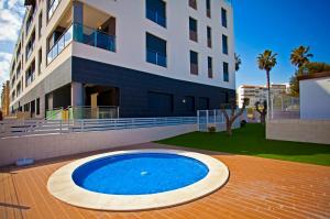 a large blue pool in front of a building at Apartamento Pinada Beach- La Mata in La Mata