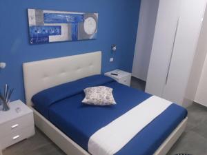 een blauwe slaapkamer met een bed met een kussen erop bij B&B La Grotta in Nicolosi