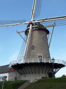 un molino de viento sentado en la cima de una colina en Bed en Breakfast en Bike, en Sommelsdijk