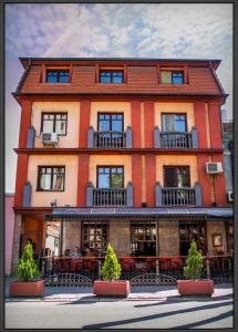 - un grand bâtiment orange avec des tables devant dans l'établissement Marilyn Apartments, à Smederevo